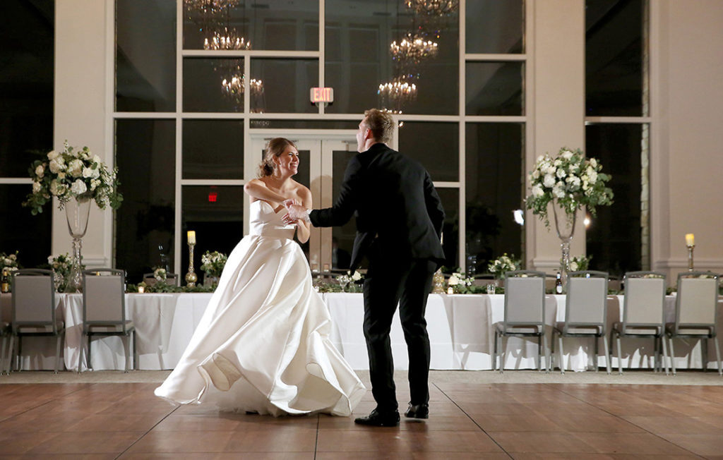 A bride and groom dance on an empty dance floor at their wedding